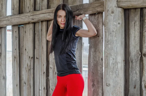 Szép fiatal sportos lány piros nadrágját a háttérben — Stock Fotó