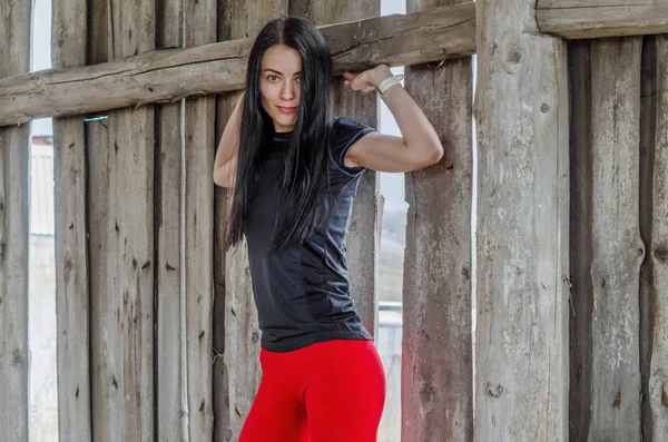 Hermosa chica atlética joven en leggings rojos en el fondo — Foto de Stock