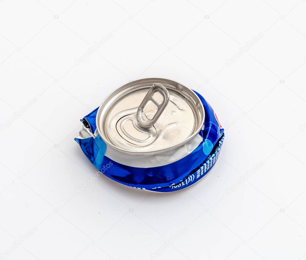 Crushed compressed aluminum carbonated drink can. Pollution, waste, ecology