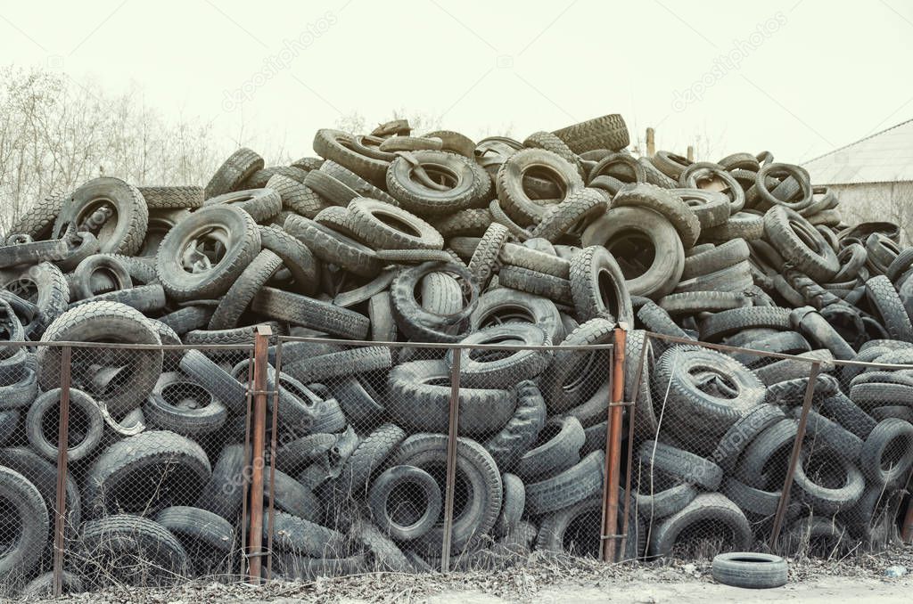 Old used damaged car tires at the dump