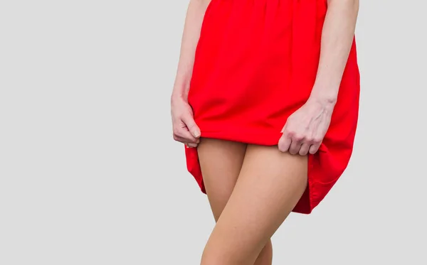 Lány a piros ruha felemeli a szegély, show lábak. Női egészség, — Stock Fotó
