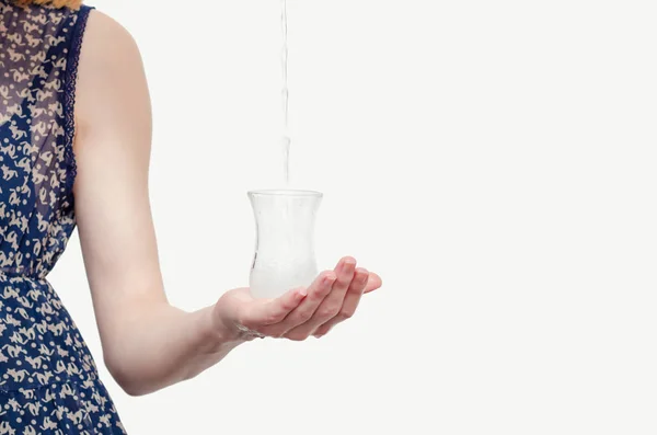 Hand einer jungen Frau, die einen Glasbecher mit Wasser hält — Stockfoto