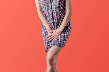 Genç kadın ellerini alt karına basmış. Tıbbi CONC