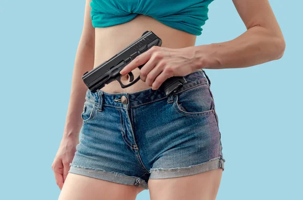 Chica sostiene una pistola negra en su mano — Foto de Stock