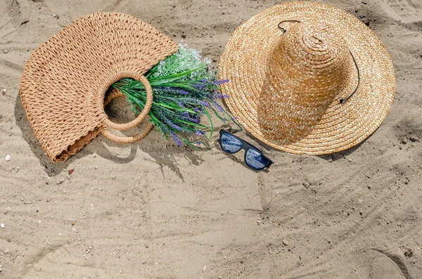 Sluneční brýle se slaměnou čapkou a pytlem ležící na písku na Bea — Stock fotografie