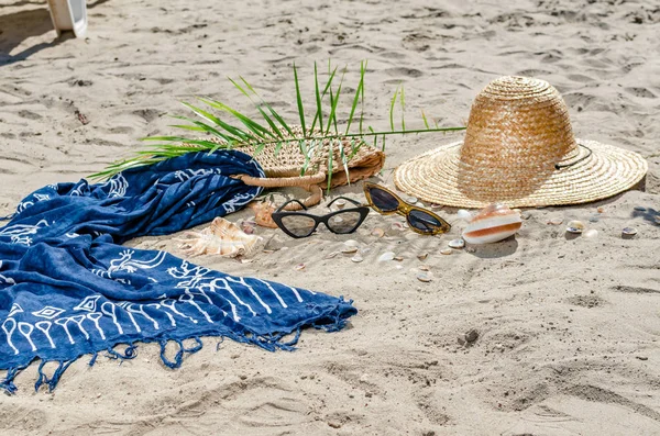 Hasır şapka, çanta, gadget, güneş gözlüğü, kabukları ve yeşil yaprakları yalan 