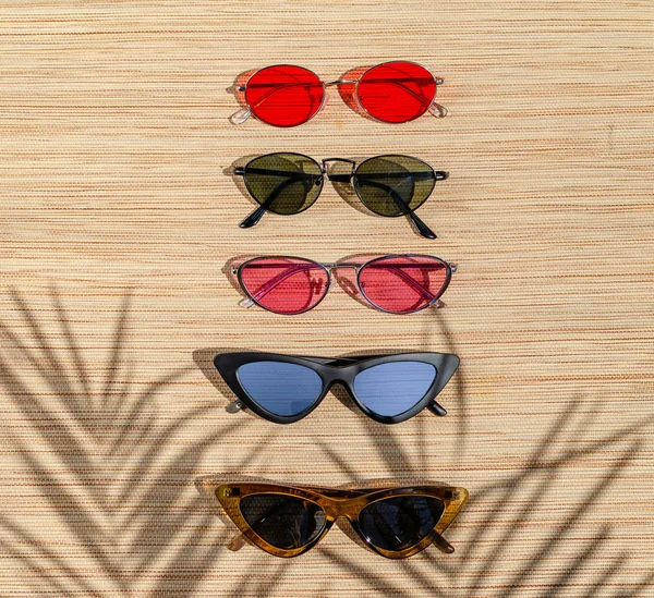 Diferentes gafas de sol en un respaldo de paja en el sol. Escena de verano —  Fotos de Stock
