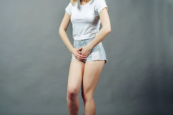 Mujer con piernas delgadas vestido con pantalones cortos de mezclilla presiona él — Foto de Stock
