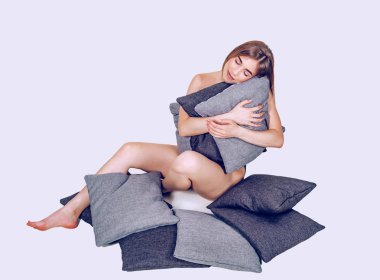 Yerde otururken rahat kız sarılma yastıklar. Uyku, 