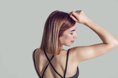 Genç kız izleyiciye geri yükseltilmiş bir el ile duruyor, onun hea