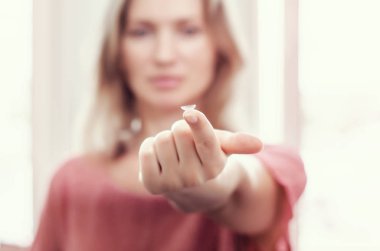 Kadın uzatılmış parmağın ucunda kontakt lens gösterir. Optik, Vizyon, Optik Aletler.