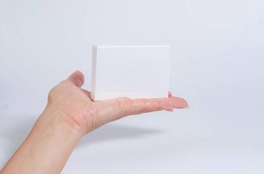 Kadın el beyaz bir tablet tutun, kartvizit, beyaz bir arka plan üzerinde kutu.