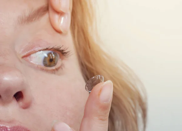 Vrouw voegt een contactlens in het oog. Close-up, binnenlandse scène. Optiek, visie, optische instrumenten — Stockfoto