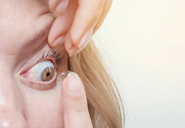 Frau setzt Kontaktlinse ins Auge. — Stockfoto