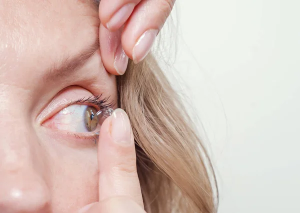 Frau setzt Kontaktlinse ins Auge. — Stockfoto