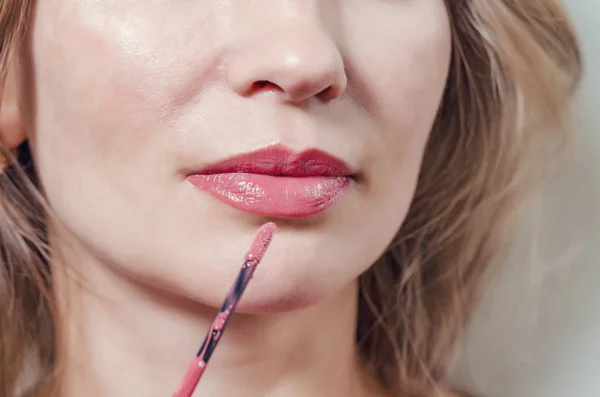 Los labios femeninos están pintados con lápiz labial rojo, primer plano . — Foto de Stock