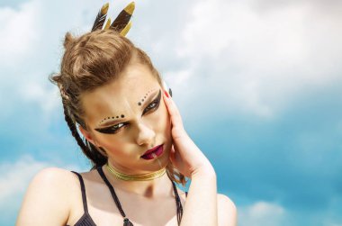 Agresif makyaj savaş boya hint amazon doğa üzerinde gökyüzüne karşı poz veren bir kızın portresi