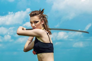 Elinde kılıç ile gökyüzü arka plan üzerinde makyaj amazon savaş boya boyama ile kız portresi