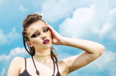 Agresif makyaj savaş boya hint amazon doğa üzerinde gökyüzüne karşı poz veren bir kızın portresi