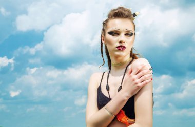 Agresif makyaj savaş boya hint amazon doğa üzerinde gökyüzüne karşı poz veren bir kızın portresi