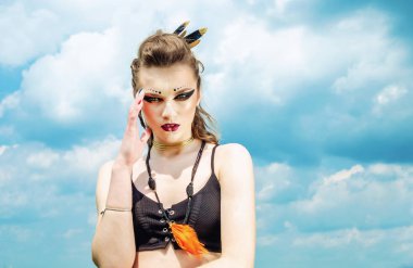 Agresif makyaj savaş boya hint amazon doğa üzerinde gökyüzüne karşı poz veren bir kızın portresi