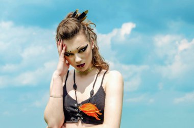 Agresif makyaj savaş boya hint amazon doğa üzerinde gökyüzüne karşı poz veren bir kızın portresi