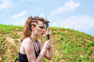 Amazon makyaj ile Savaşçı kız kollarında bir kılıç tutar