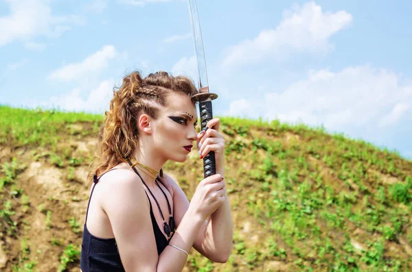 Amazon makyaj ile Savaşçı kız kollarında bir kılıç tutar