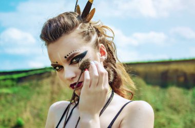 Agresif makyaj amazon viking ile bir kız Portresi yüzüne dikenli çiçekler devedikeni presler.