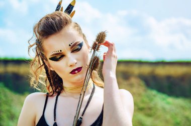 Agresif makyaj amazon viking ile bir kız Portresi yüzüne dikenli çiçekler devedikeni presler.