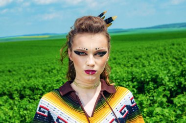 Makyaj Amazon, Viking, agresif savaş boyası ile bir kız portresi. Arka plan gökyüzünde bir poncho giymiş, yeşil alan