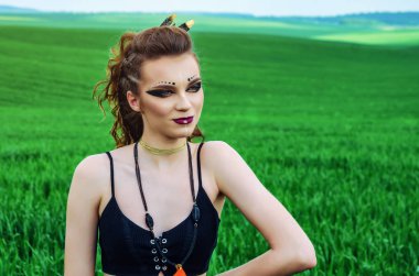 Agresif makyaj kız, yeşil buğday alanında amazon karakteri.