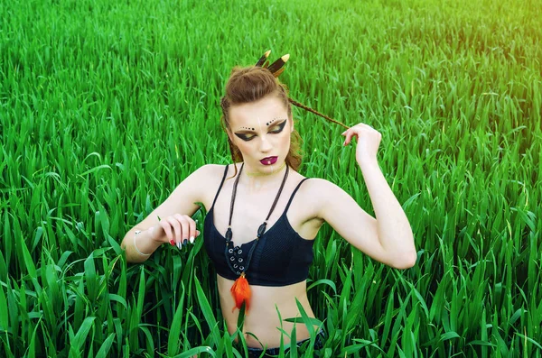 Chica de maquillaje agresivo, personaje amazónico en un campo de trigo verde . —  Fotos de Stock