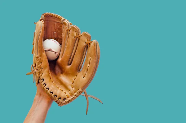 La mano en un guante de béisbol de cuero atrapó una pelota sobre un fondo verde — Foto de Stock