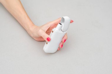 Kadının eli elektronik sigara için bir kutu tutuyor.