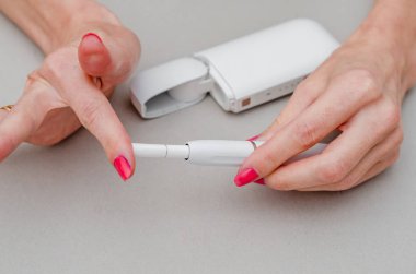 Kadının ellerinde elektronik sigara var. Ağızlığa bir sigara yerleştirin. Sigara, sağlık, mücadele, bağımlılık