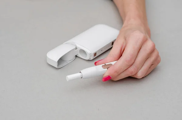 La mano de la mujer sostiene una caja para un cigarrillo electrónico . —  Fotos de Stock