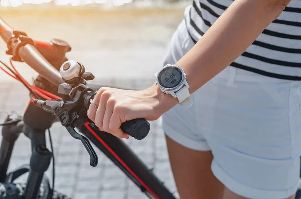 Frauenhand am Fahrradlenker, weiße Smart Watch am Handgelenk — Stockfoto