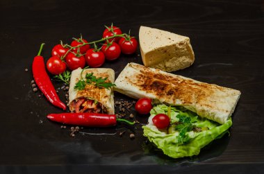 Shawarma siyah arka planda tavuk etiyle kesilmiş. Peynir, kırmızı biberli maydanoz. Sokak Yemeği, Fast Food, Doğu Yemekleri.