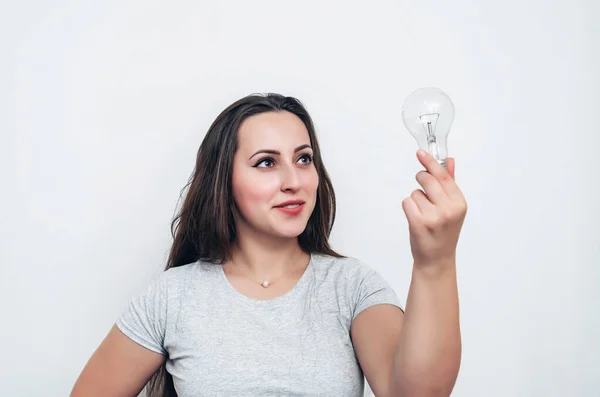 Girl holds a light bulb in hand. New idea, successful startup.