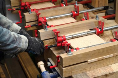 Red Joiner 'ın klempleri ürüne sabitlenmiş, tahtaları yapıştırıyor. Marangozluk atölyesinde ahşap parçaların birleştirilmesi