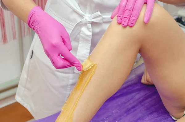 Mãos Esteticista Aplicam Pasta Açúcar Para Retirar Cabelo Pernas Menina — Fotografia de Stock