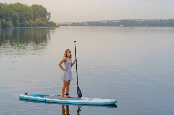 Jonge Vrouw Een Jurk Zwemt Het Meer Surfplank — Stockfoto