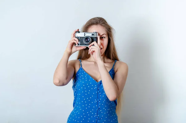 美丽的女人穿着蓝色的夏装拍照 一个女孩拿着一把老式的银灰色照相机 — 图库照片