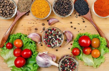 Mutfak tatları için çeşitli baharat ve sebzeler. Tahtaya dizilmiş çeşitli baharatlar ve baharatlar. Küçük kaseler ve içinde malzemeler olan tahta kaşıklar. Restoran menüsü için görüntü. Üst görünüm.