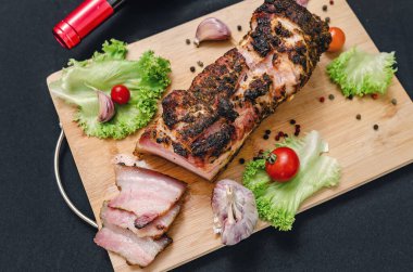 Şarap seti, domuz eti, sebze, baharat. Tahtada, fırında domuz eti, sebze ve baharatla servis ediliyor. Siyah arka plan. Akşam yemeği için bir takım ürünler. Restoran menüsü.