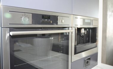 Modern Mutfak elektrikli fırın, ızgaralı soba ve kahve makinesi ışıkta bulanıklık.
