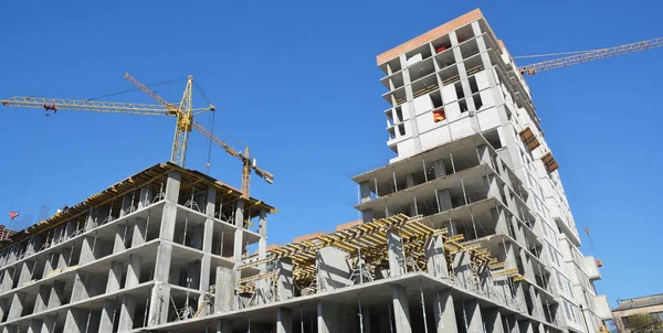 Crane construction panorama with building contractors on the top. Economic growth concept with industrial landscape.