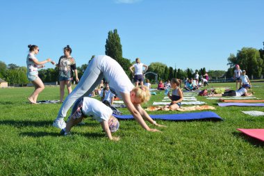 Kiev, Ukrayna - Haziran, 25, 2018: Yoga sınıfları dışında açık hava. Yoga, çocuk, Aile Yoga, anne ve oğul çocuklar.