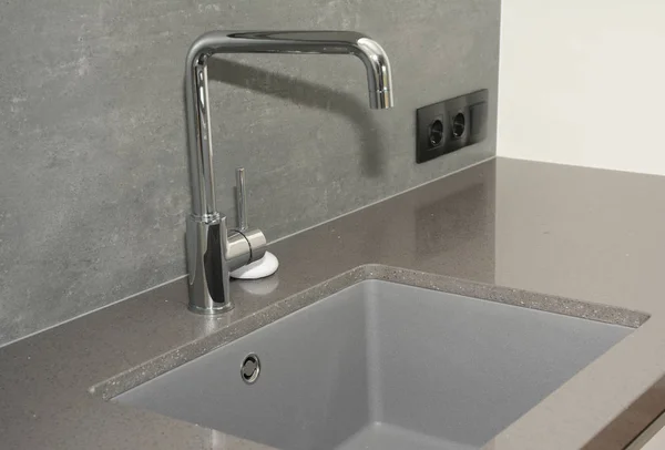 Ceramic kitchen sink. Modern kitchen metal faucet and  ceramic kitchen sink.